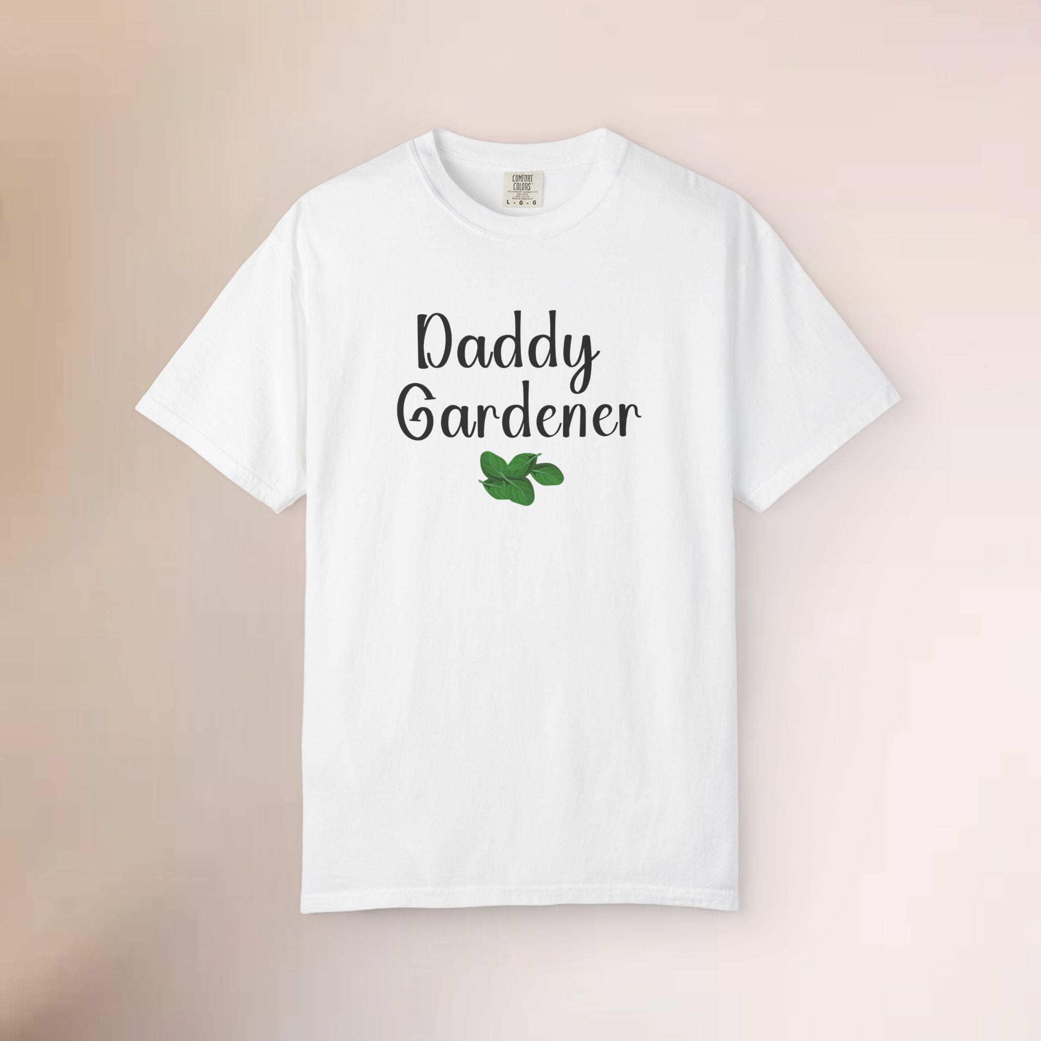 White t-shirt with 'Daddy Gardener' text and a leaf graphic on a beige background