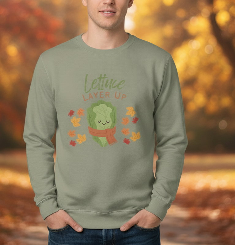 Person wearing a green sweatshirt with a lettuce graphic and 'Lettuce Layer Up' text against an autumn background.