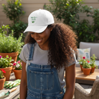 White cap with 'Wake Up & Garden' text and leaf design on a beige background