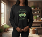 Person wearing a black sweatshirt with a green graphic and text in a home setting