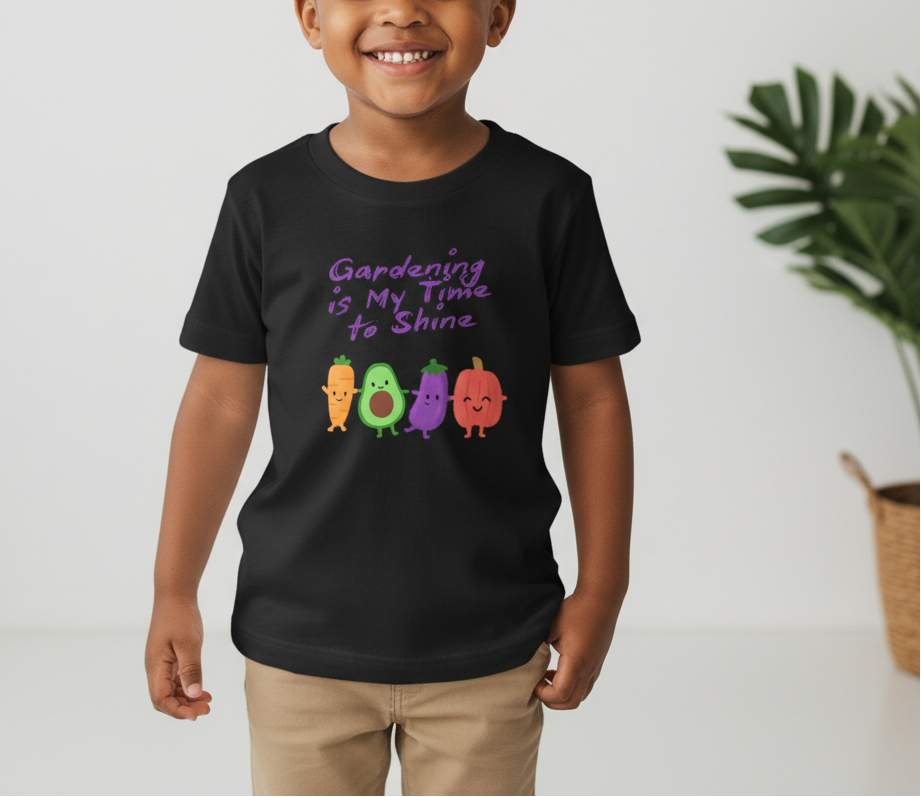 Child wearing a black t-shirt with colorful vegetables and text, standing against a light background.
