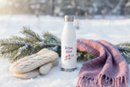 White insulated bottle with 'Grow, Girl!' text and floral design in the snow.