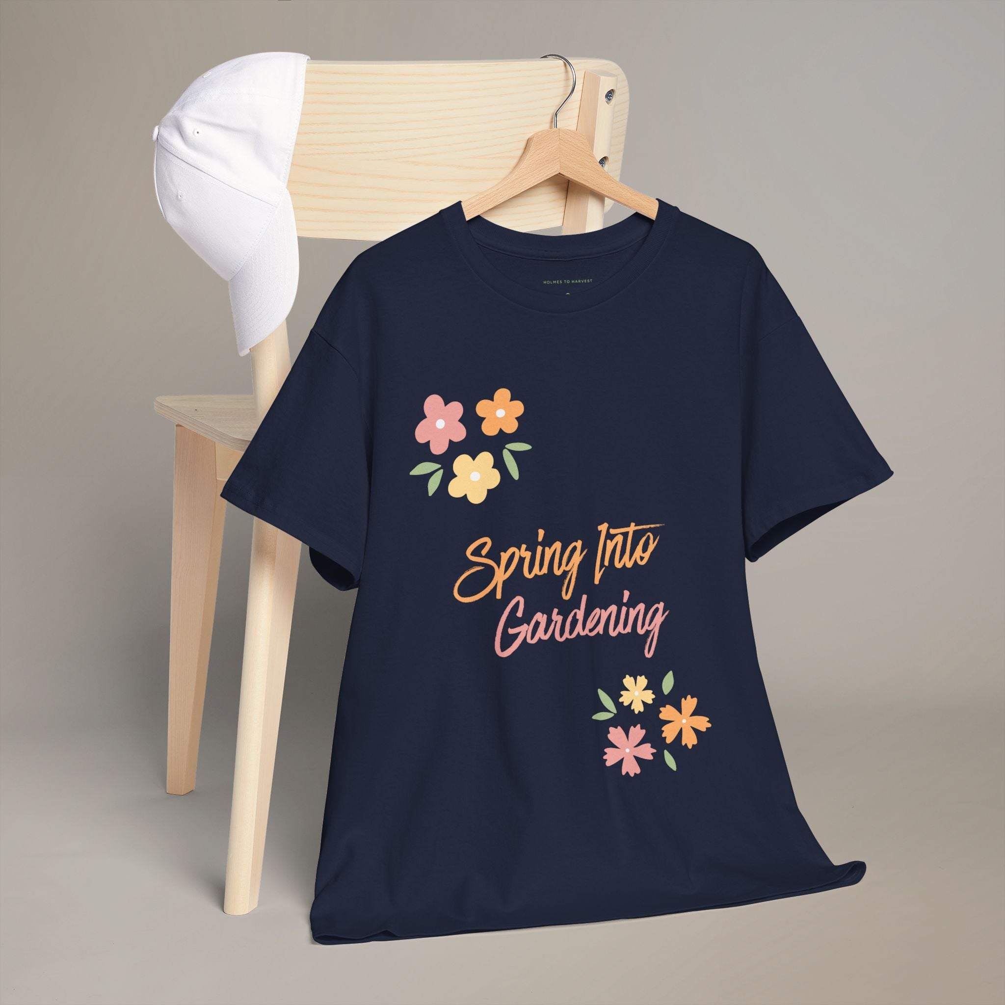 Green t-shirt with 'Spring Into Gardening' text and flowers on a wooden chair.