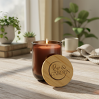 Candle with wooden lid labeled 'Rise & Garden' on a wooden surface with plants in the background