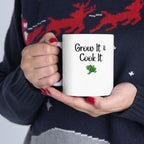 Person holding a white mug with 'Grow It & Cook It' text, wearing a dark sweater with red deer design.