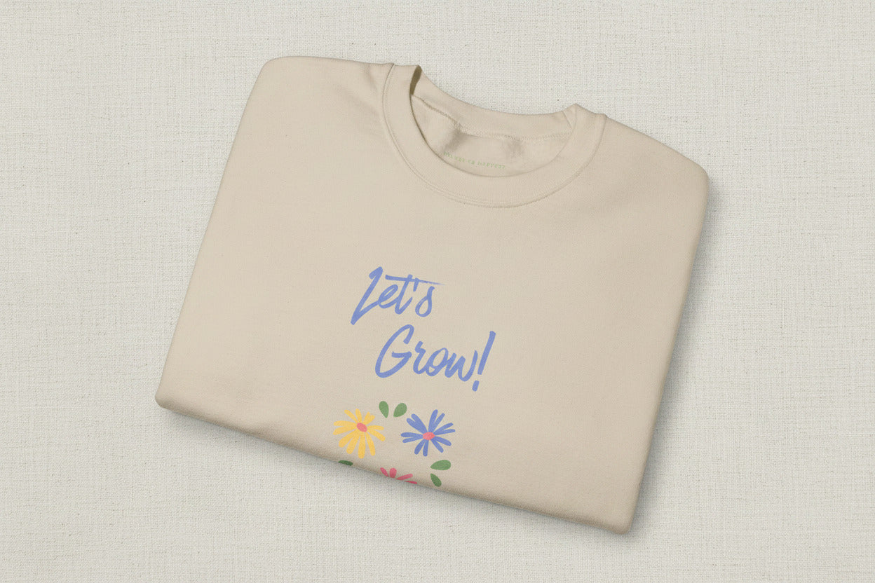Beige sweatshirt with 'Let's Grow!' text and floral designs on a white background