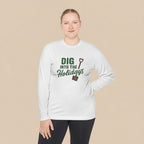 Person wearing a white long-sleeve shirt with 'DIG INTO THE HOLIDAYS' text, standing indoors.