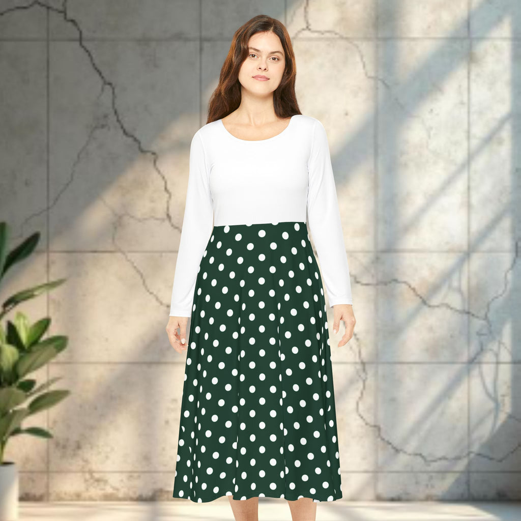 Woman wearing a white top and green polka dot skirt standing against a light stone wall.