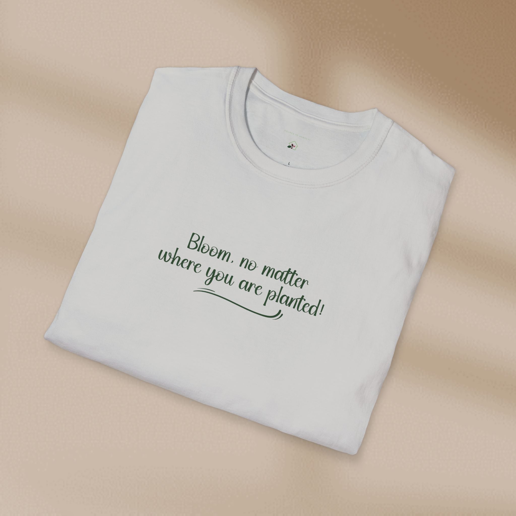 Folded white t-shirt with text on a beige background