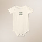 White baby onesie with text on a beige background