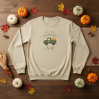 Beige sweatshirt with 'Garden Fresh' graphic on a wooden surface with pumpkins and leaves.