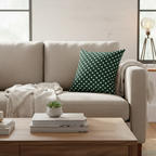 Beige sofa with a green polka dot pillow in a living room setting.