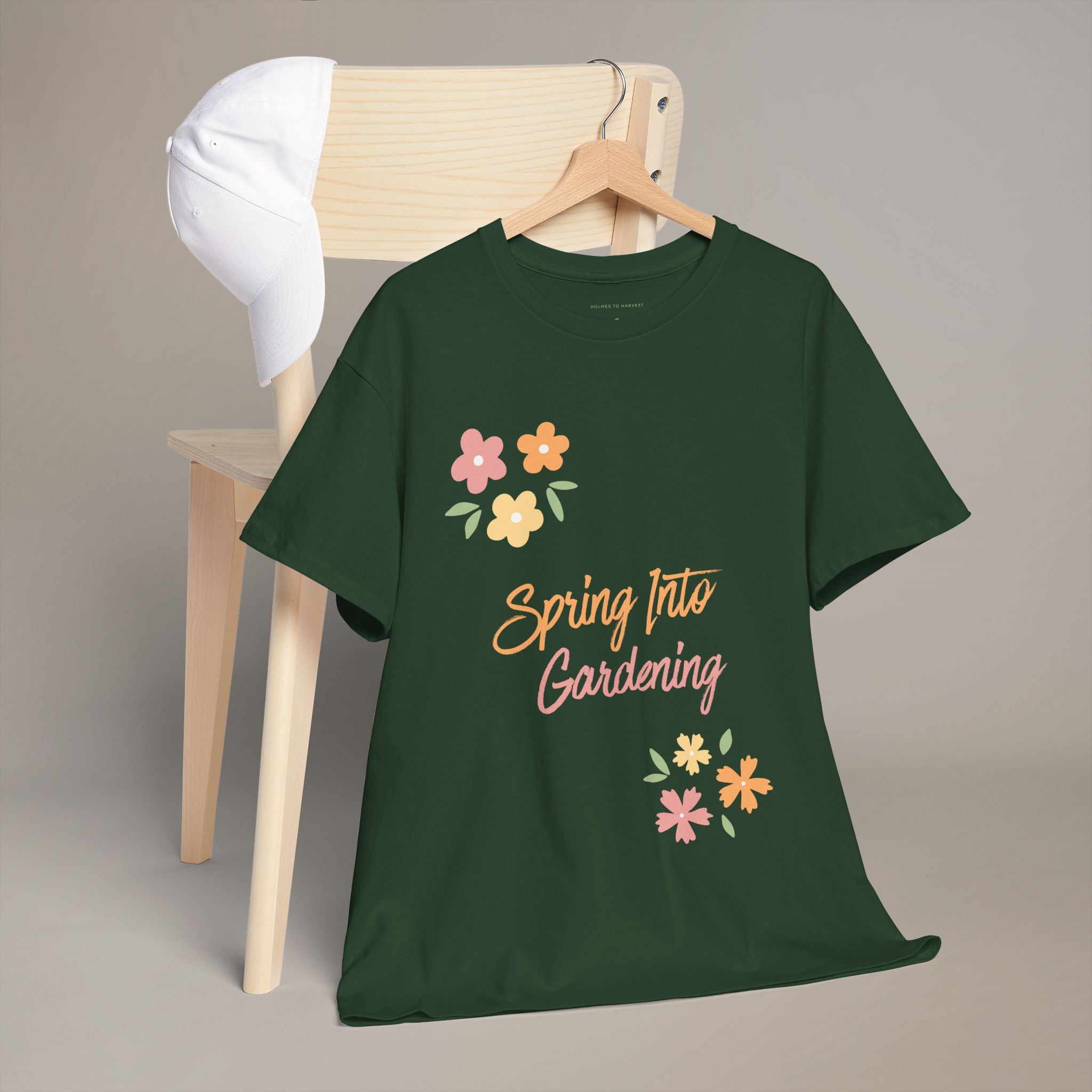 Green t-shirt with 'Spring Into Gardening' text and flowers on a wooden chair.