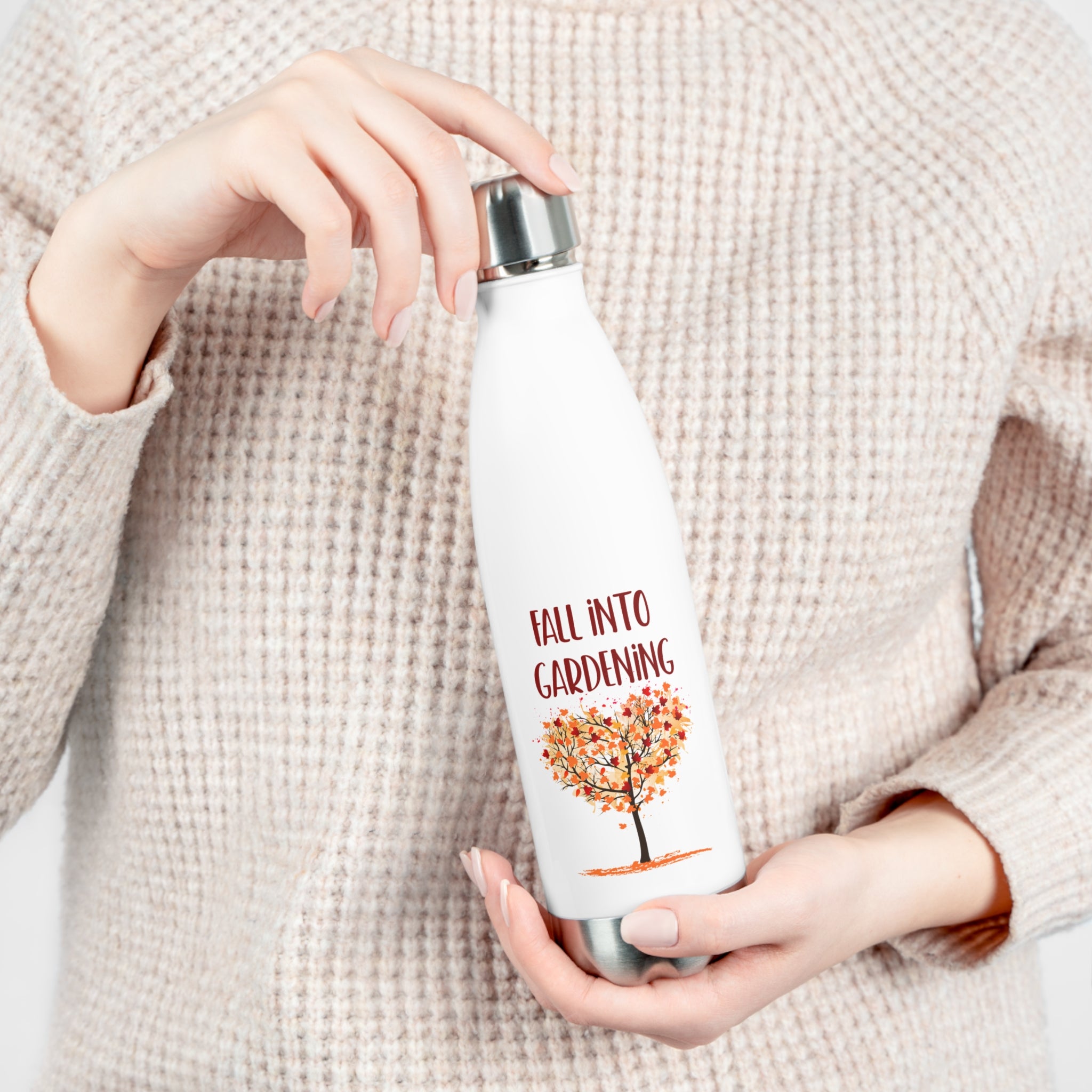 Person holding a white water bottle with 'Fall into Gardening' text and tree design.