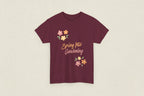 Maroon t-shirt with 'Spring Into Gardening' text and floral designs on a white background