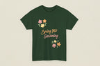 Green t-shirt with 'Spring Into Gardening' text and floral designs on a white background
