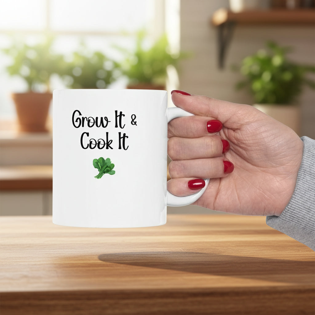 Hand holding a white mug with 'Grow It & Cook It' text and a green leaf symbol on a white background