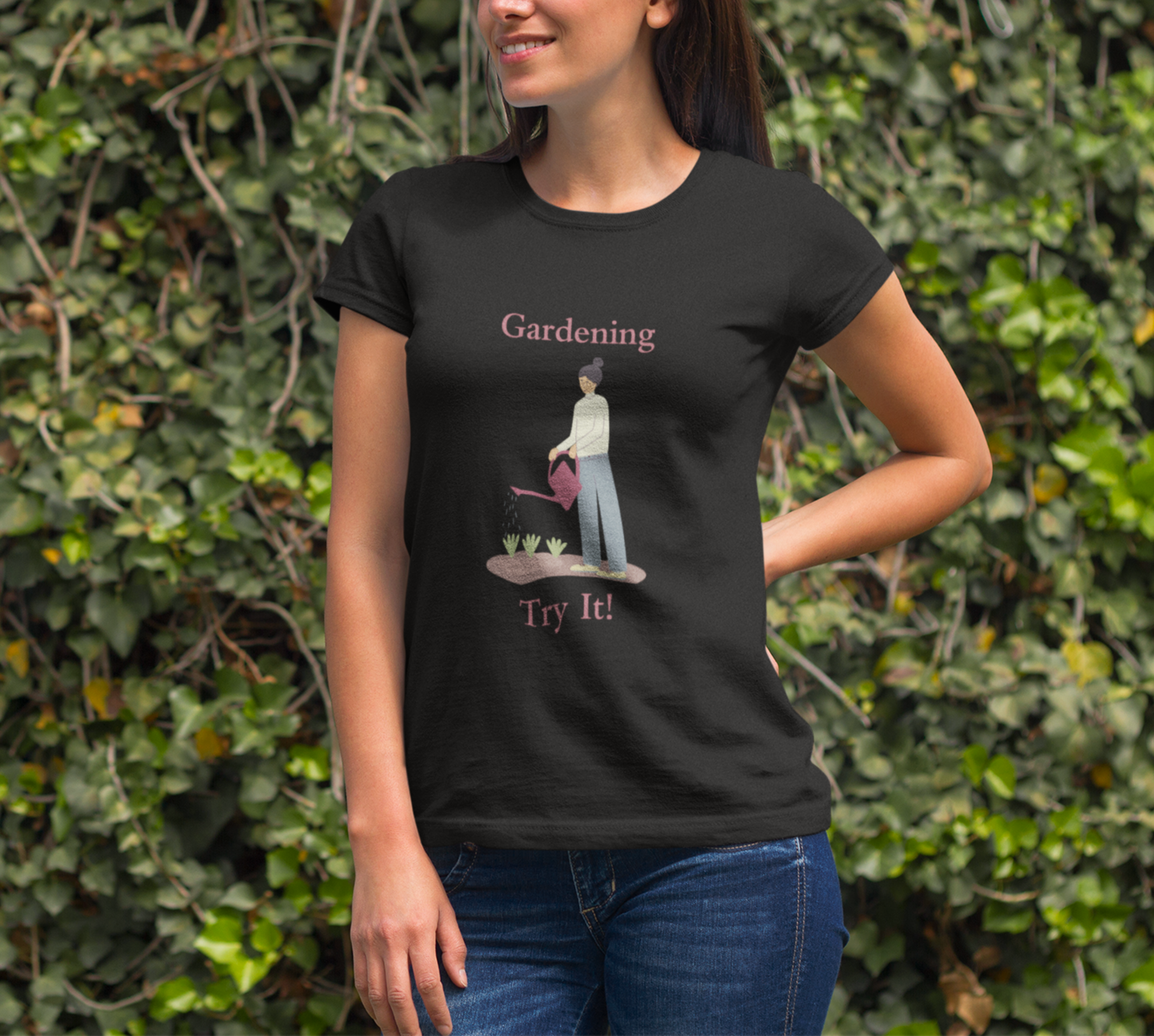 Woman wearing a black t-shirt with a gardening graphic and text, standing against a green leafy background.
