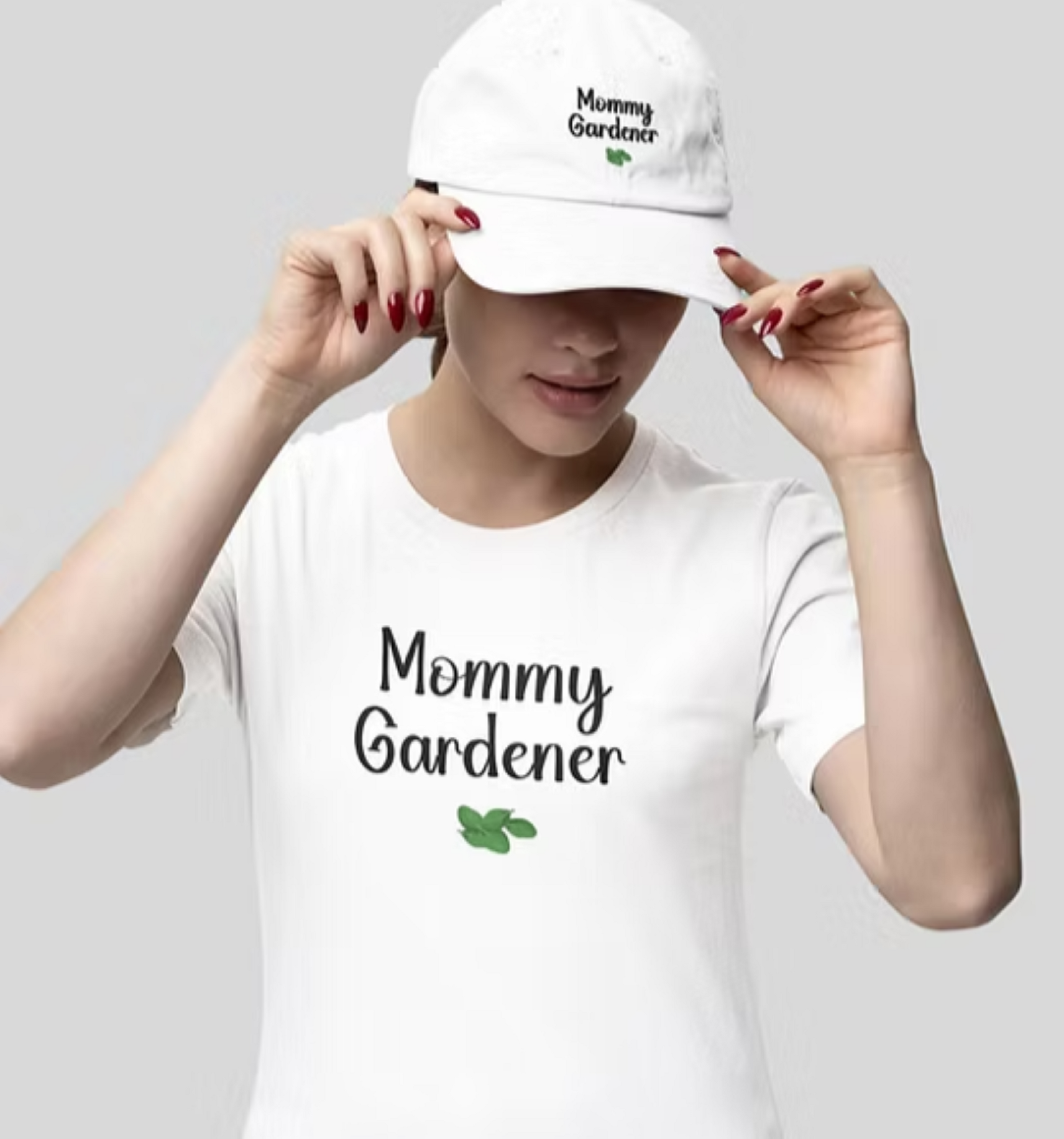 Person wearing a white t-shirt and cap with 'Mommy Gardener' text on a gray background