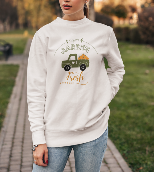 Woman wearing a white sweatshirt with a graphic design in a park