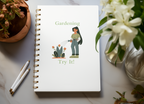 Notebook with gardening illustration and text on a table with plants and pens
