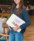 Woman holding a white pouch with text and graphics in an indoor setting