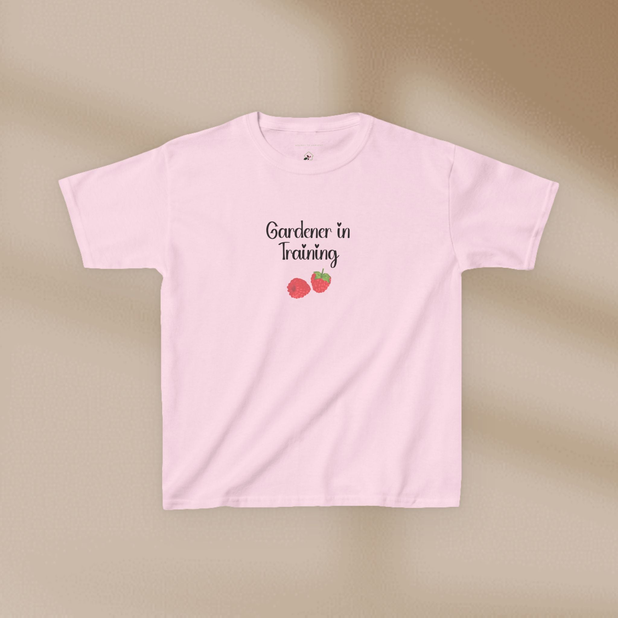 Pink t-shirt with 'Gardener in Training' text and strawberry graphics on a beige background