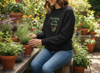 Person wearing a black sweatshirt with 'Gardening is my Therapy' text in a garden setting