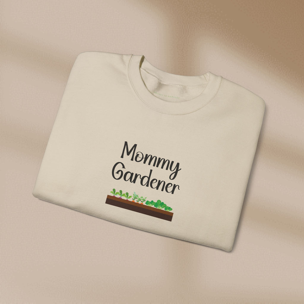 Folded beige sweatshirt with 'Mommy Gardener' text and garden graphic on a beige background
