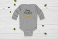 Gray baby onesie with 'Baby Gardener' text and emoji on a white background