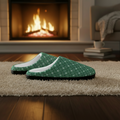 Green patterned slippers on a rug in front of a fireplace