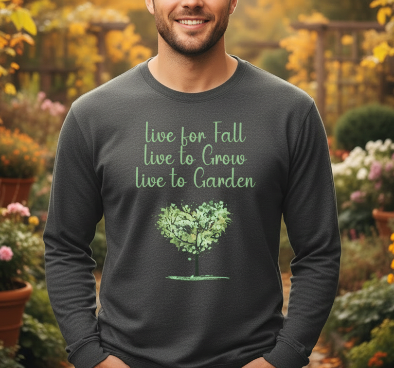 Man wearing a dark long-sleeve shirt with a tree graphic and text in a garden setting