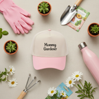 Pink and white cap with 'Mommy Gardener' text, surrounded by gardening tools and plants on a beige background.