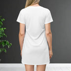 Person wearing a white t-shirt dress against a dark gray background