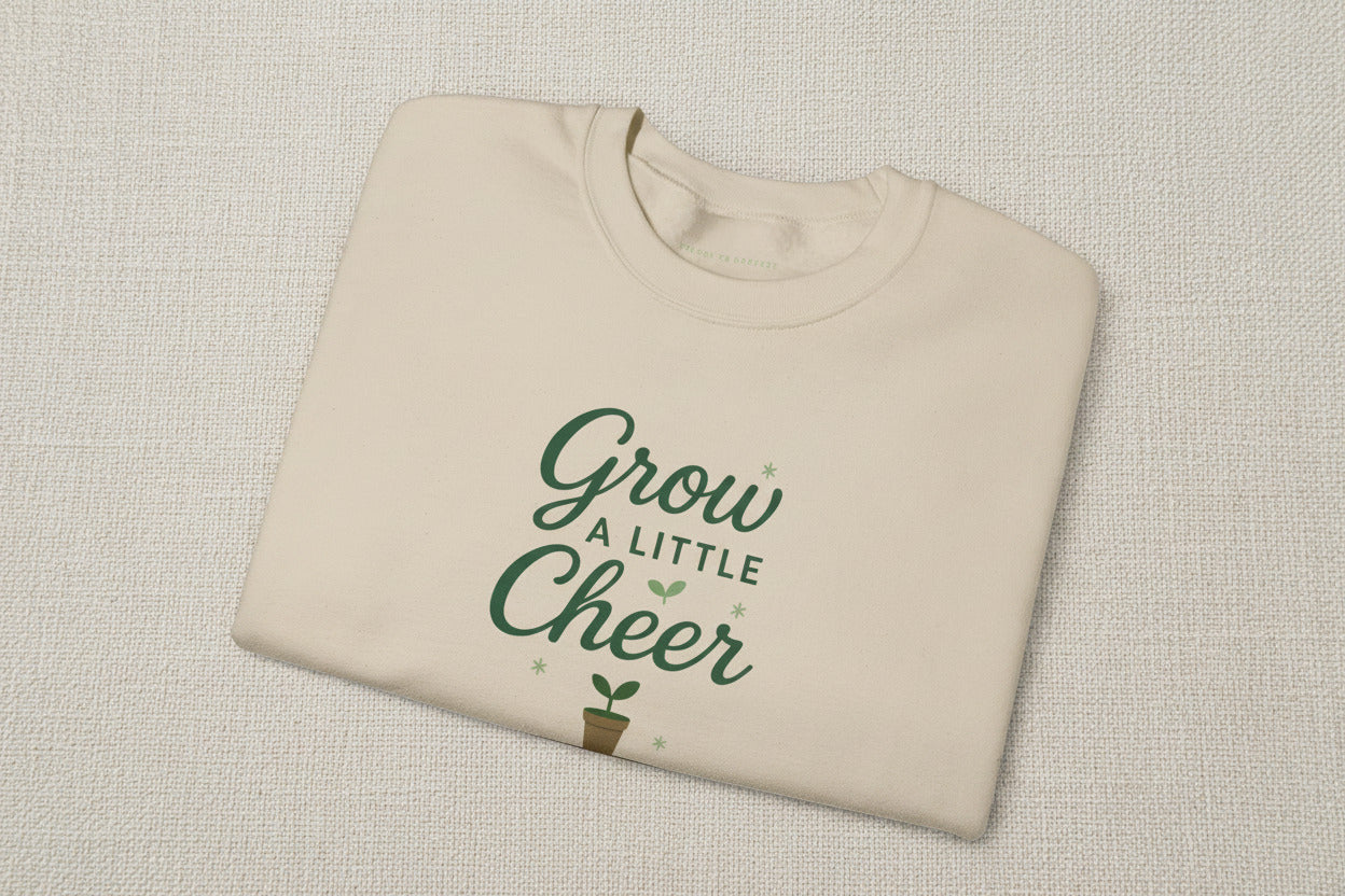 Beige t-shirt with 'Grow a Little Cheer' text on a white background