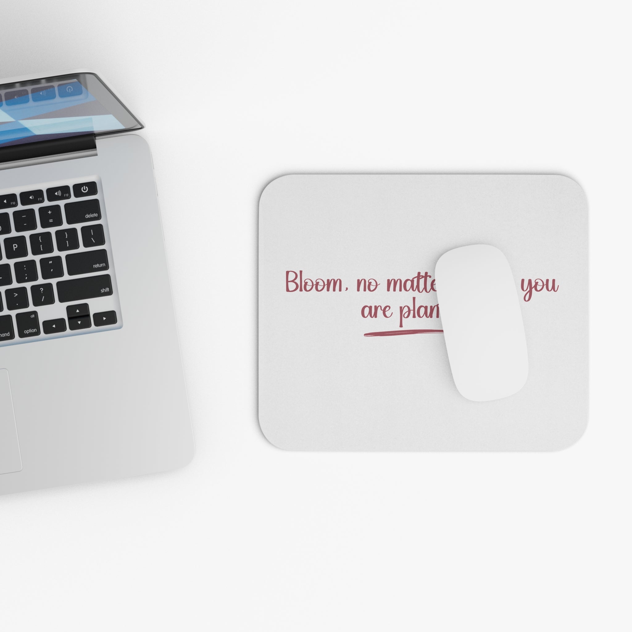 Laptop with a mouse pad featuring text on a white surface