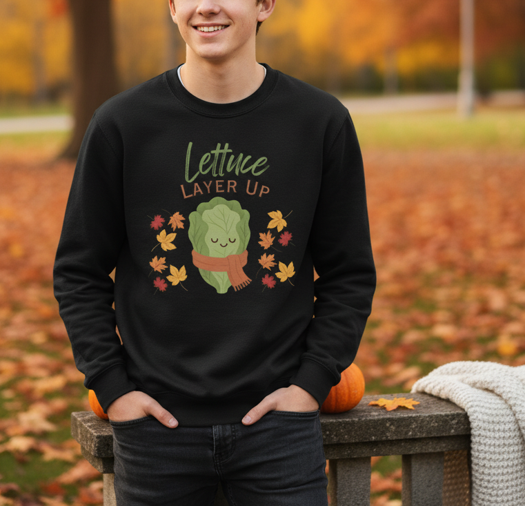 Person wearing a black sweatshirt with a lettuce graphic in an autumn setting