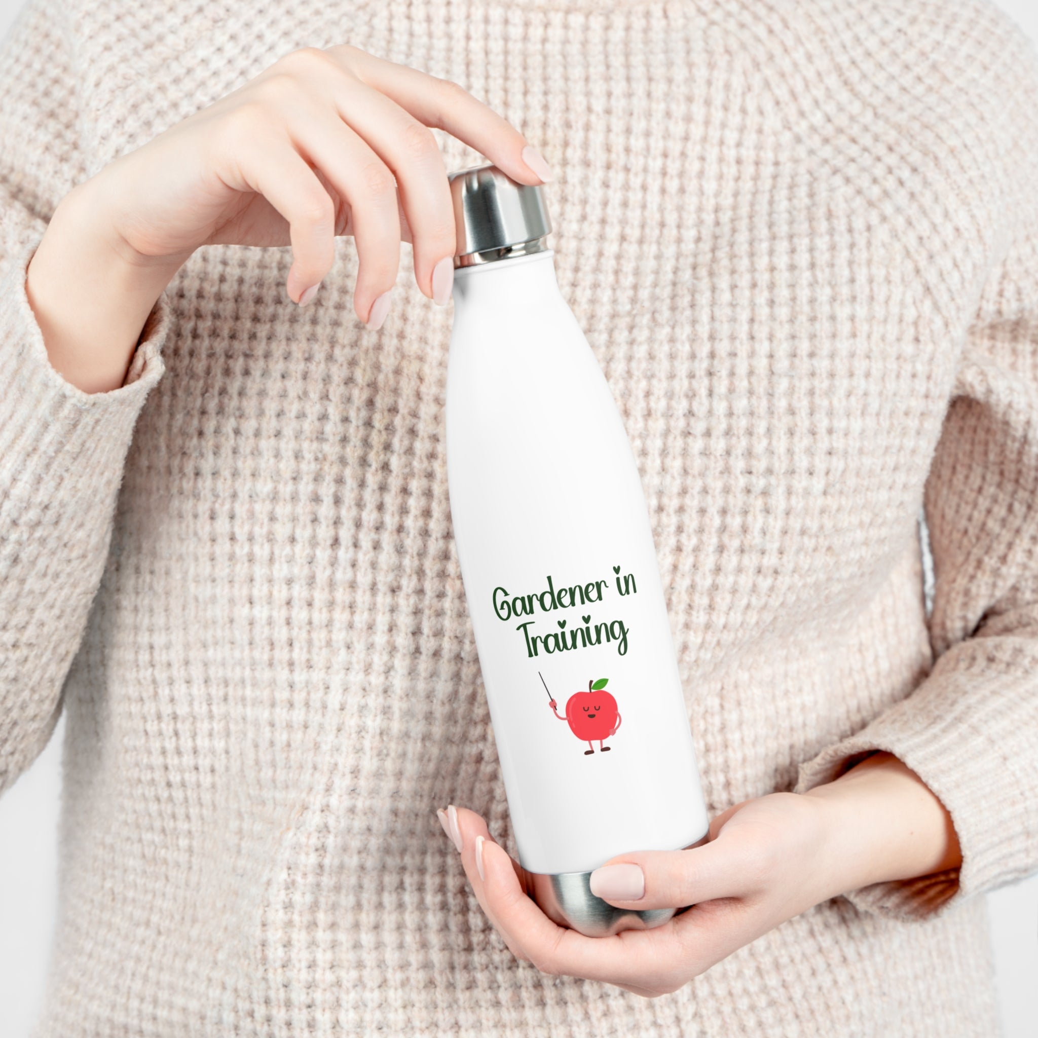 Person holding a white water bottle with 'Gardener in Training' text and tomato graphic.
