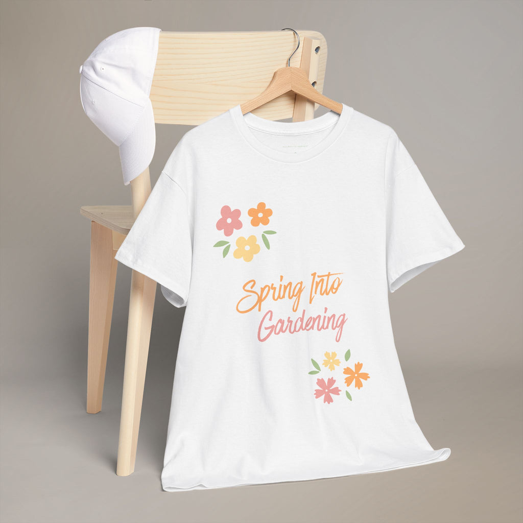 White t-shirt with 'Spring Into Gardening' text and flowers on a wooden chair.
