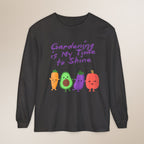 Black long-sleeve shirt with colorful vegetable graphics and text on a beige background