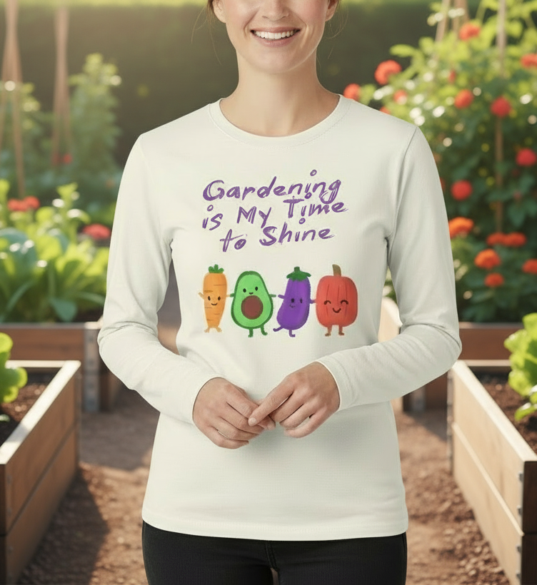 Person wearing a white long-sleeve shirt with vegetable graphics and text in a garden setting