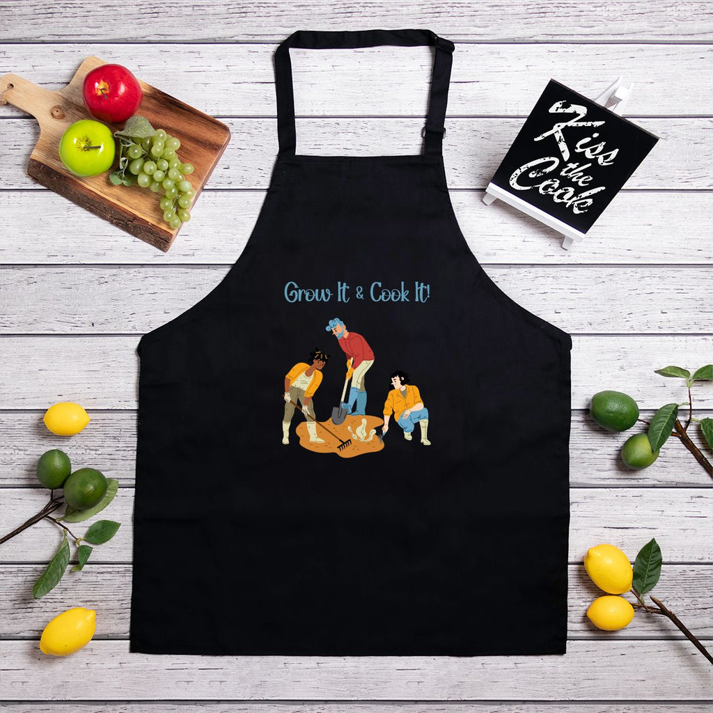 Black apron with gardening design and text on a wooden surface with fruits and a sign.
