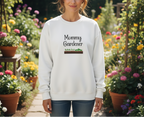 Person wearing a white sweatshirt with 'Mommy Gardener' text in a garden setting