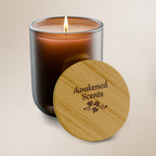 Candle with wooden lid labeled 'Awakened Scents' on a beige background