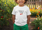 Child wearing a 'Gardener in Training' t-shirt in a garden setting