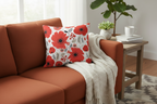 Gray sofa with a floral pillow and a wooden side table with a plant and books.