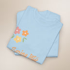 Folded light blue shirt with floral design and text on a beige background