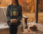 Person wearing a sweater with a graphic design sitting on a swing during autumn.