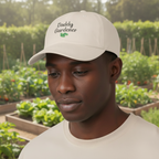 Person wearing a cap with 'Daddy Gardener' text in a garden setting