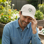 Man wearing a 'Daddy Gardener' cap in a garden setting